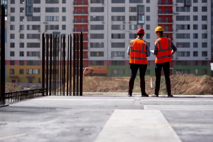 two-civil-engineers-dressed-in-orange-work-vests-a-2023-11-27-05-13-22-utc